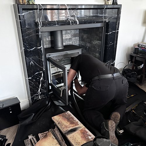 Inserting sweeping rods through stove